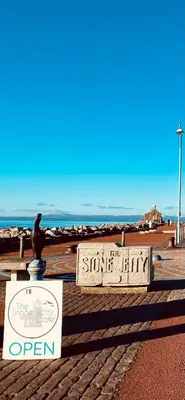 a sign on the beach with a bird sitting on top of it at Eden Stay 5 Bedroom House in Morecambe