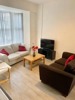 a living room with a couch and a tv at Eden Stay 5 Bedroom House in Morecambe
