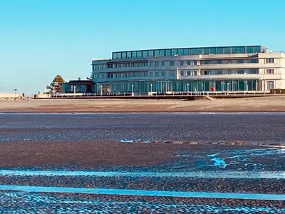 a large building on the side of a beach at Eden Stay 5 Bedroom House in Morecambe