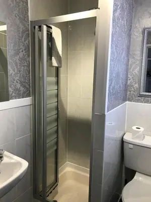 a bathroom with a shower and a toilet and a sink at The Rutland in Blackpool