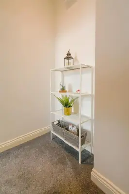 a white shelf with a plant on it in a room at Suite in the heart of Great Harwood in Great Harwood