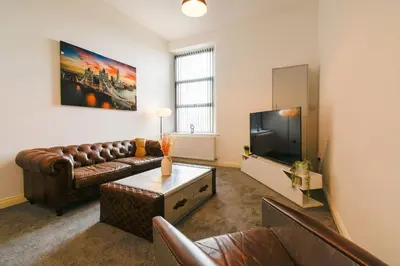 a living room with a couch and a flat screen tv at Suite in the heart of Great Harwood in Great Harwood
