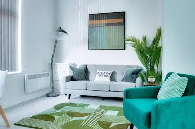 a living room with a couch and a rug at Modern 2 bedroom flat - 15 minutes to Liverpool in Birkenhead