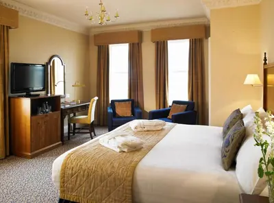a hotel room with a bed and a desk and a television at Imperial Hotel Blackpool in Blackpool