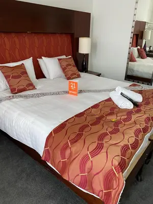 a bedroom with a large bed with an orange sign on it at The Bailey Hotel Blackpool in Blackpool