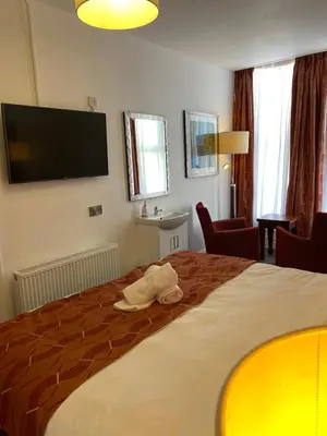 a hotel room with a bed with a towel on it at The Bailey Hotel Blackpool in Blackpool