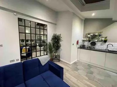 a living room with a blue couch and a kitchen at Fantastic Liverpool City Centre Apartments, Fenwick Street in Liverpool