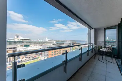 a balcony with a view of a cruise ship at 1BR Apt - Balcony - River View in Liverpool