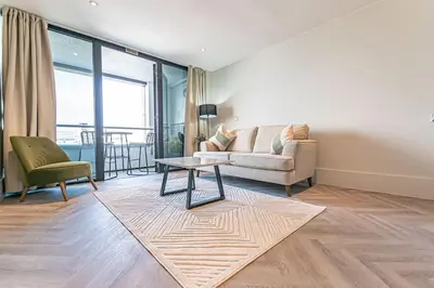 a living room with a couch and a table at 1BR Apt - Balcony - River View in Liverpool