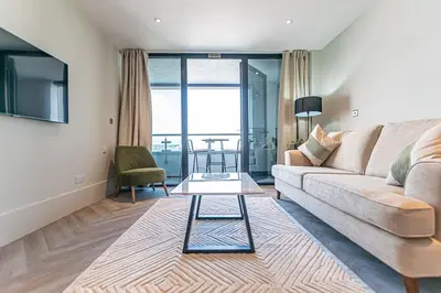 a living room with a couch and a table at 1BR Apt - Balcony - River View in Liverpool