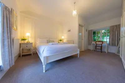 a bedroom with a white bed and a window at Meadowcroft in Lindale
