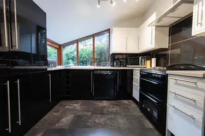 a kitchen with white cabinets and black appliances at Meadowcroft in Lindale