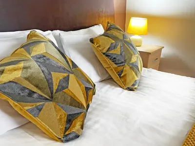 a bed with two pillows on top of it at The President Hotel in Blackpool