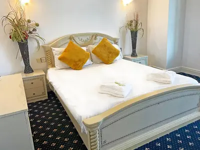 a bedroom with a white bed with yellow pillows at The President Hotel in Blackpool