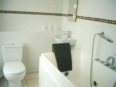 a white bathroom with a toilet and a sink at The President Hotel in Blackpool
