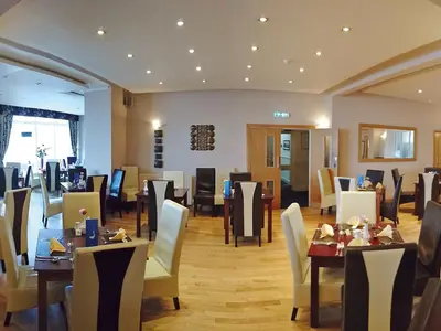 a dining room with tables and chairs in a restaurant at The President Hotel in Blackpool