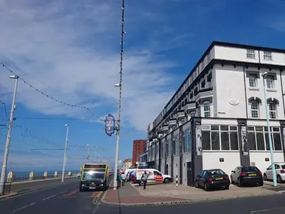 a building with cars parked on the side of a street at The President Hotel in Blackpool