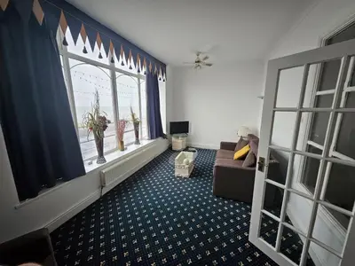 a living room with a couch and a window at The President Hotel in Blackpool