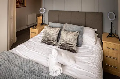 a large bed with white sheets and pillows at Lakeland Lodge 9B Arnside , Carnforth ,Lancaster , LA61BH in Carnforth