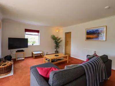 a living room with a couch and a tv at Pembroke in Grange Over Sands