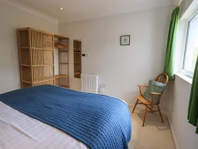 a bedroom with a blue bed and a chair at Pembroke in Grange Over Sands