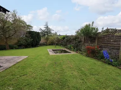 a garden with a lawn and a fence at Pembroke in Grange Over Sands