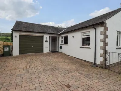 a house with a garage and a brick driveway at Pembroke in Grange Over Sands