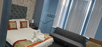 a bedroom with a bed and a chair next to a window at North Ocean Hotel in Blackpool