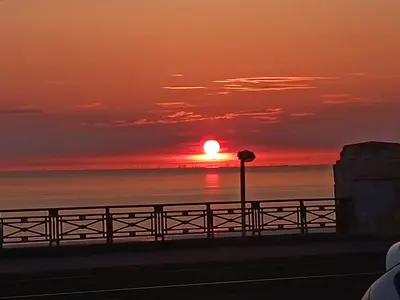 a sunset over the ocean with a fence at North Ocean Hotel in Blackpool