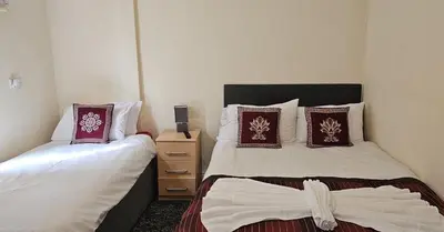 a hotel room with two beds and a night stand at North Ocean Hotel in Blackpool