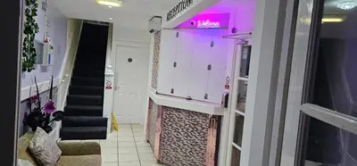 a hallway with stairs and a neon sign on the wall at North Ocean Hotel in Blackpool