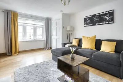 a living room with a couch and a table at LIVERPOOL HOME with FREE PARKING in West Derby