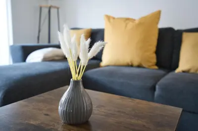 a vase sitting on a wooden table with a couch at LIVERPOOL HOME with FREE PARKING in West Derby