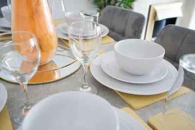 a table with white plates and wine glasses on it at LIVERPOOL HOME with FREE PARKING in West Derby