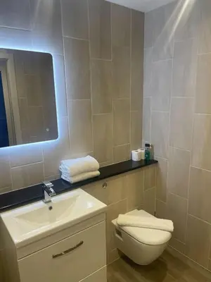 a bathroom with a toilet and a sink and a mirror at 1 Bed Apt - Balcony - City View - Great Location in Liverpool