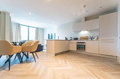 a kitchen and dining room with a table and chairs at 1 Bed Apt - Balcony - City View - Great Location in Liverpool