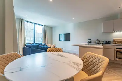 a kitchen and a living room with a table and chairs at 1 Bed Apt - Balcony - City View - Great Location in Liverpool