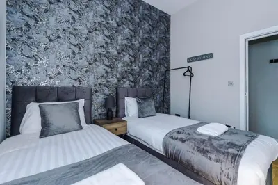 a bedroom with two beds and a wall with a wallpaper at Stylish Apartment located in the City Centre of Liverpool - Web-exclusive offers at a-kapartments in Liverpool