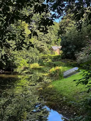 a stream of water with a house in the background at Eller How House - Private Regency Property & Lake in Lindale