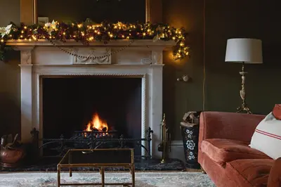 a living room with a fireplace with christmas lights at Eller How House - Private Regency Property & Lake in Lindale