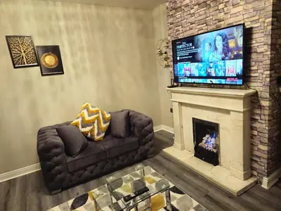 a living room with a fireplace and a television at Clifton House, For Holidays, Contractors, Relocation, Work, Etc, Free Parking and Wifi in Preston
