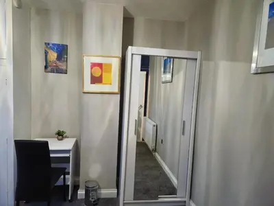 a mirror in a room with a table and a chair at Clifton House, For Holidays, Contractors, Relocation, Work, Etc, Free Parking and Wifi in Preston