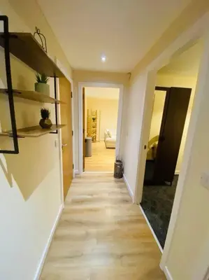 a hallway of a home with wooden floors and shelves at Liverpool City Centre Modern Apartment fits 6 people in Liverpool