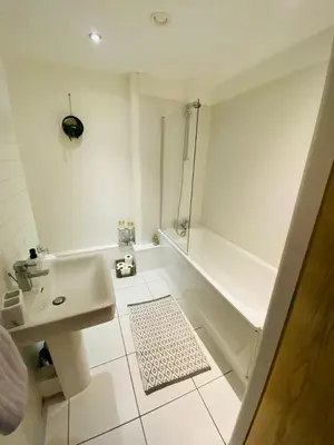 a white bathroom with a sink and a shower at Liverpool City Centre Modern Apartment fits 6 people in Liverpool