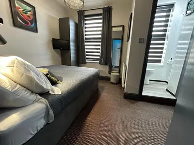 a hotel room with a bed and a bathroom at Hotel Neon in Blackpool