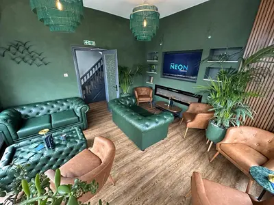 a living room with a couch and chairs and a television at Hotel Neon in Blackpool
