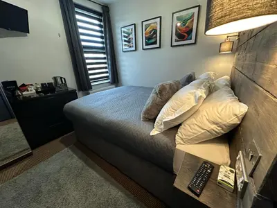 a bedroom with a bed with pillows and a lamp at Hotel Neon in Blackpool