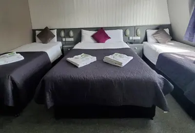 a hotel room with two beds with towels on them at Brooklyn Hotel in Blackpool