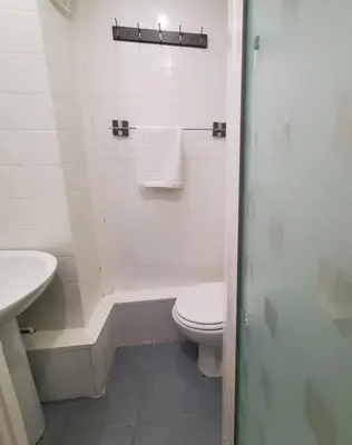 a white bathroom with a toilet and a sink at Brooklyn Hotel in Blackpool