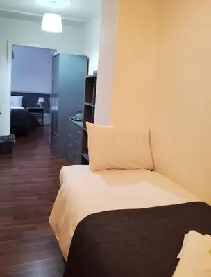 a hotel room with a bed and a living room at Brooklyn Hotel in Blackpool
